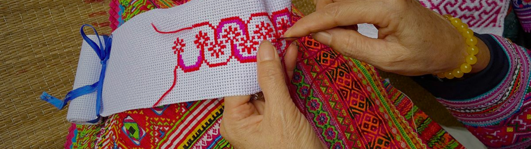 Colorful Hmong paj ntaub story cloth with intricate hand-embroidered geometric patterns