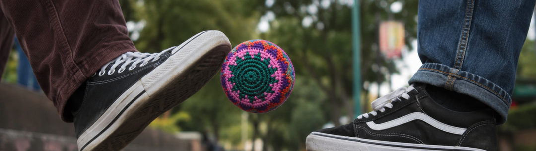 Person playing with a colorful Lumily handmade Guatemalan hacky sack outdoors